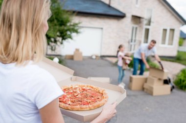 kısmi görünümünü yeni binasının önünde karton kutuları açma kızı ve eşi ise pizza tutan kadın 