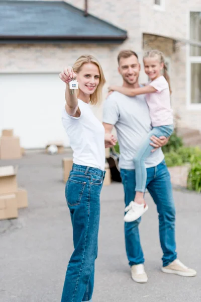 Woman Showing Key Trinket Her Husband Standing Holding Daughter Front — Stock Photo, Image