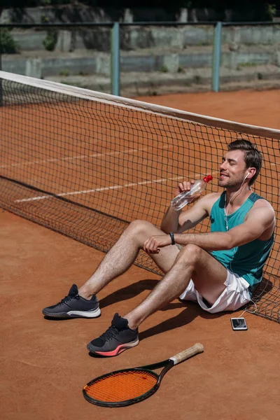 Jonge Gelukkig Man Zittend Grond Drinkwater Tennis Training — Stockfoto