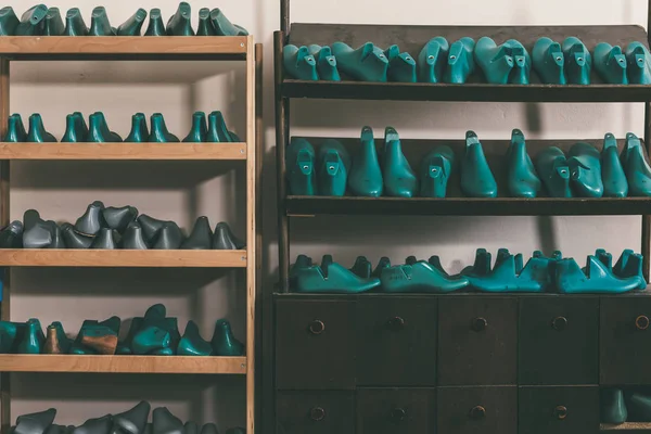 Plastic footwear workpieces on shelves at cobbler shop — Stock Image Plastic Footwear Workpieces Shelves Cobbler Shop Stock Photo