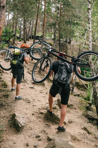 Rear View Trial Bikers Carrying Bikes Backs Forest Going Uphill — Free Stock Photo