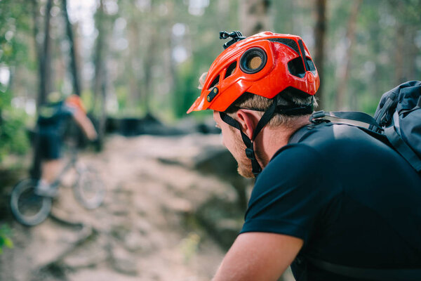 close-up shot of young trial biker in helmet at forest