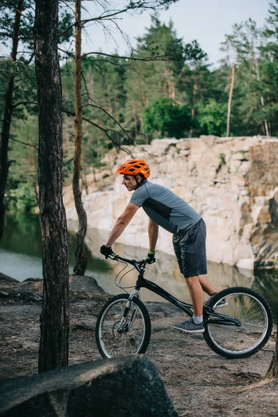 Joven Ciclista Trial Montar Aire Libre Frente Lago Bosque — Foto de stock gratuita