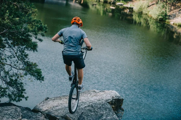 Young Trial Biker Balancing Back Wheel Rocky Cliff Lake — Stock Photo, Image