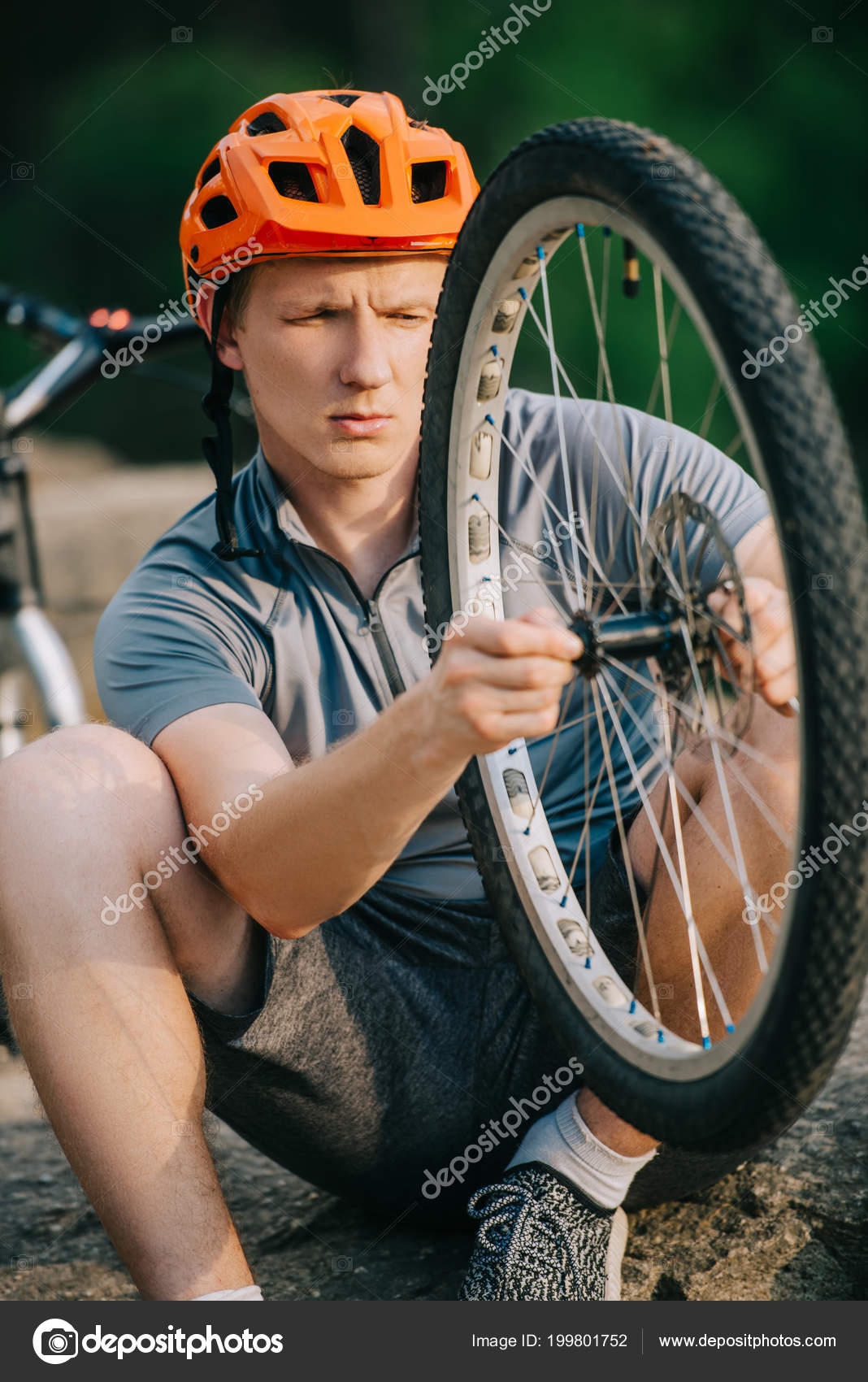 Close Shot Young Trial Biker Examining Bike Wheel Outdoors — Free Stock