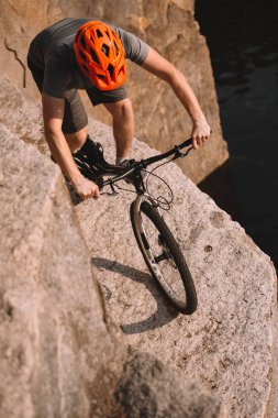 high angle view of trial biker balancing on rocks outdoors clipart