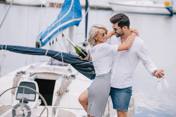 gülümseyen kız yakışıklı adam şarap şişesi ve gözlük yatta sarılma güneş gözlüğü