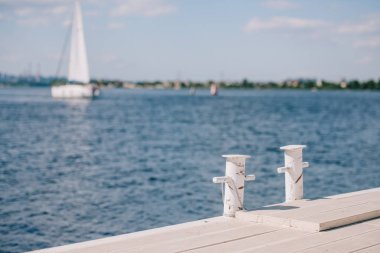 empty wooden pier and yacht on background at summer day clipart