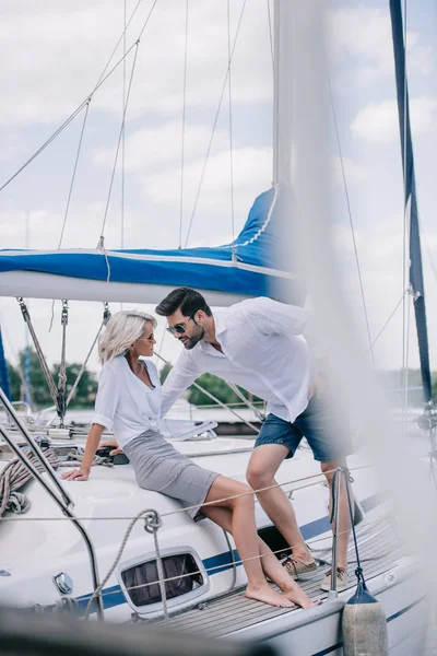 美丽的年轻夫妇的选择焦点在太阳镜看对方在游艇上 — 图库照片
