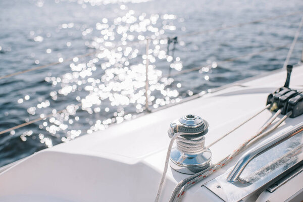 selective focus of yacht and sun glares on water surface