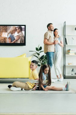 Şampanya ile dinlenme ve sarılma anne-babalar, oturan çocuklar ip ile katta evde bağladılar