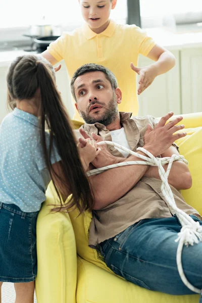 Niños Atando Padre Con Cuerda Casa Concepto Paternidad — Foto de Stock