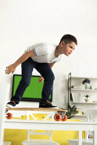 Pre Adolescent Boy Standing Skateboard Table Home — Stock Photo, Image