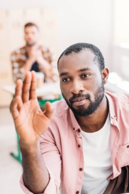 yakın çekim öğretmen soruyu cevaplamak için el yükselterek genç Afro-Amerikan öğrenci portresi
