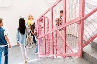 Genç öğrenciler üniversite koridor merdivenlerde yürürken