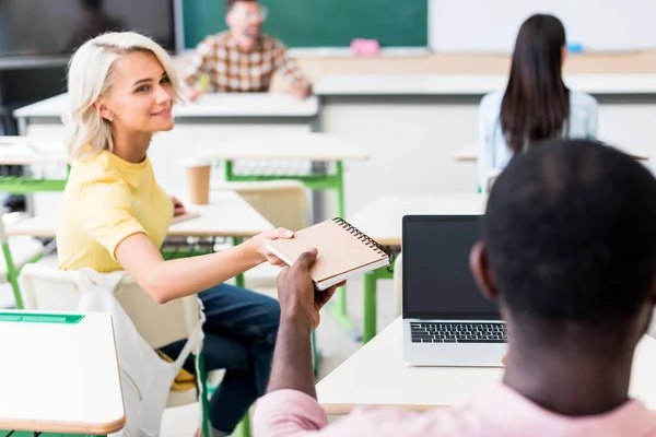 Vista Trasera Los Jóvenes Estudiantes Compartiendo Cuaderno Aula Durante Lección — Foto de Stock