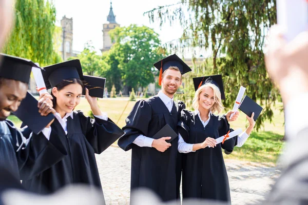 Genç mezun öğrencilerin üniversite bahçesinde birlikte vakit