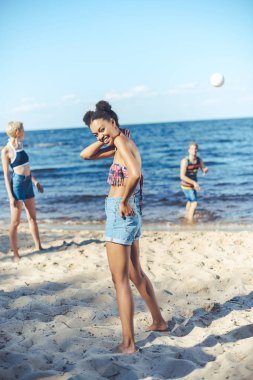 voleybol birlikte kumsalda oynarken Interracial genç arkadaşlar