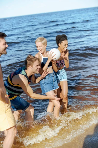 海で楽しくバレーボール ボールと友達の幸せな人種グループ — ストック写真