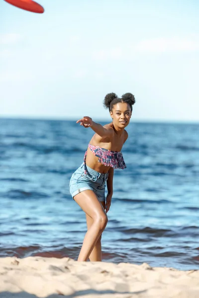 Africká Americká Žena Házení Létajícím Talířem Písečné Pláži — Stock fotografie zdarma