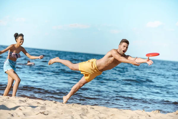 Unga Mångkulturella Par Leker Med Flygande Skiva Stranden Sommardag — Stockfoto