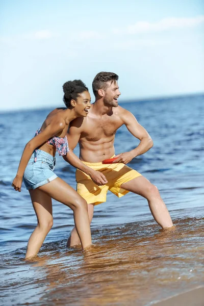 Jovem Casal Multicultural Brincando Com Disco Voador Praia Dia Verão — Fotografia de Stock