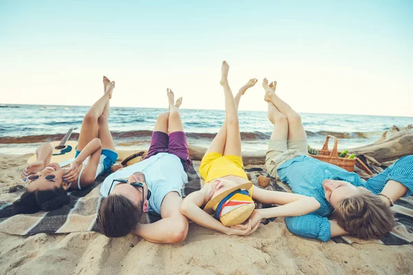 多民族の若者が砂浜で時間を過ごしながら毛布の上に横たわる — ストック写真