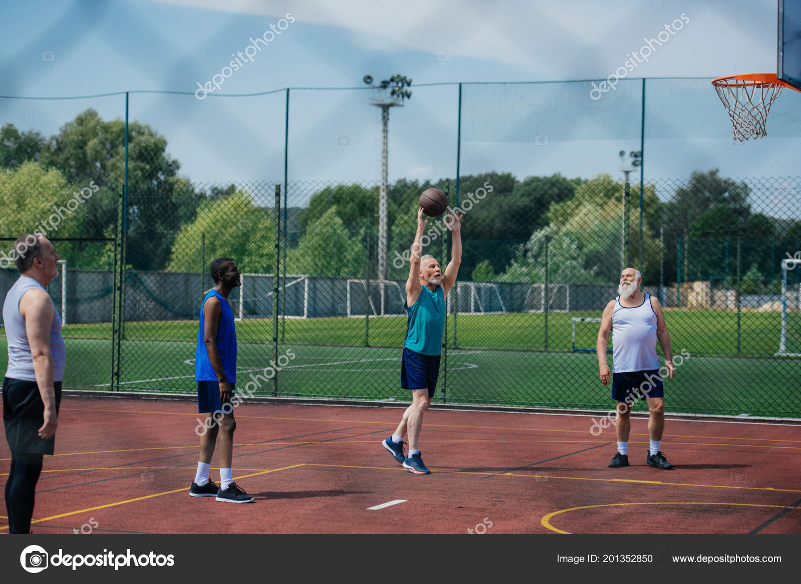 Grupo de pessoas multiétnicas jogando basquete na quadra