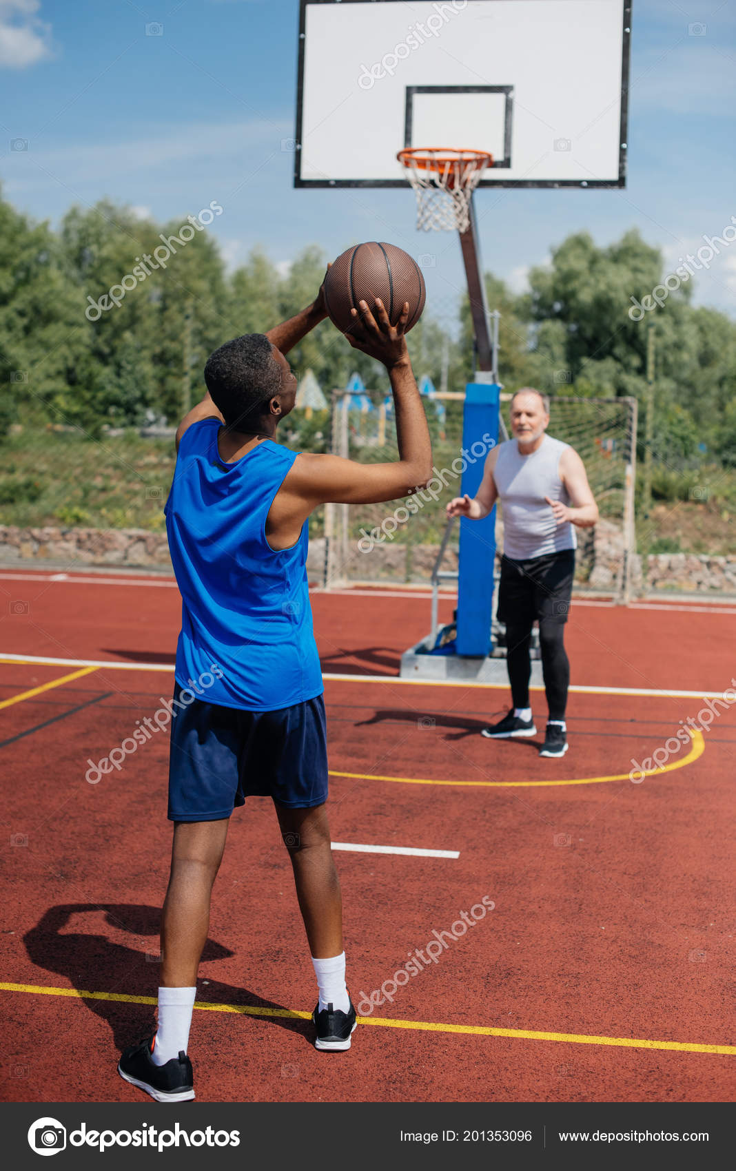 Grupo de pessoas multiétnicas jogando basquete na quadra