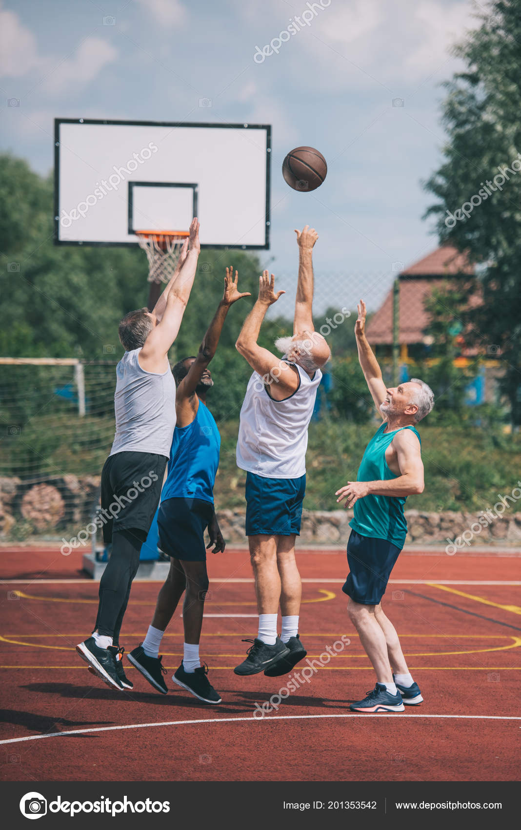 Grupo de pessoas multiétnicas jogando basquete na quadra