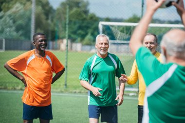 seçici odak çok ırklı eski arkadaşlar ile yeşil alan üzerinde futbol topu