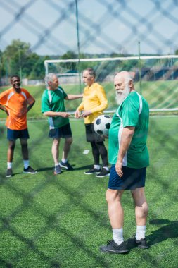 seçici odak çok ırklı eski arkadaşlar ile yeşil alan üzerinde futbol topu
