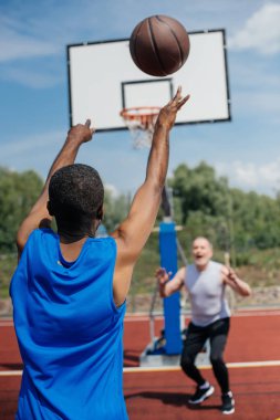 çok ırklı yaşlı erkekler basketbol birlikte sahada yaz gününde oynama.