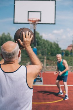 Yaşlı erkekler basketbol birlikte sahada yaz gününde oynama.
