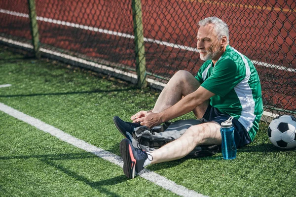 Seitenansicht Eines Alten Mannes Der Schnürsenkel Auf Dem Fußballplatz Bindet — Stockfoto