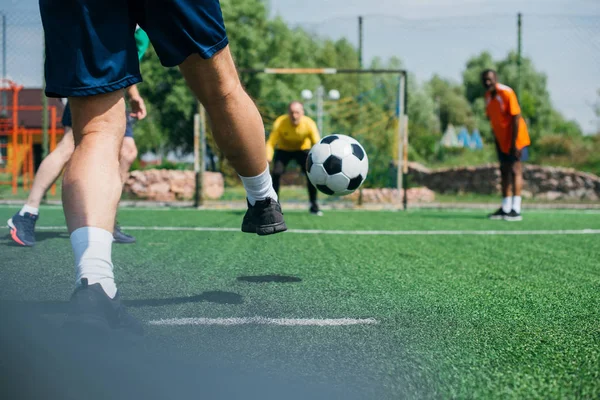 partial view of multicultural elderly friends playing football together
