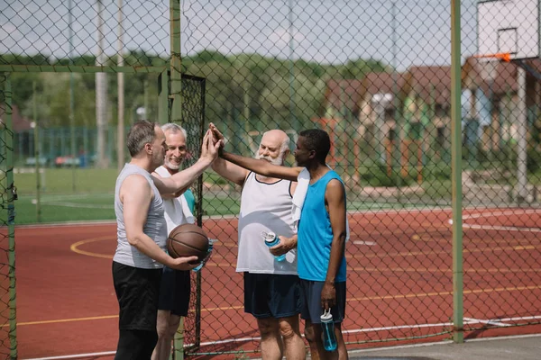 Skupina Mnohonárodnostní Staré Sportovců Basketbalový Míč Dávat Vysoké Pět Navzájem — Stock fotografie