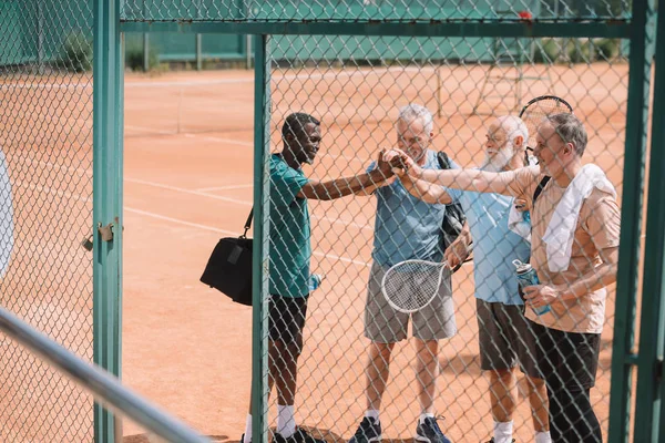 Мультикультурная Группа Пожилых Теннисистов Держащихся Руки После Игры Корте — стоковое фото