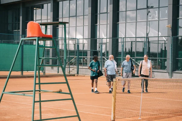 Amici Anziani Multirazziali Con Attrezzature Tennis Piedi Sul Campo — Foto Stock