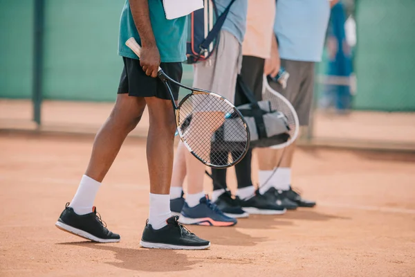 Teilansicht Multikultureller Sprinter Mit Tennisausrüstung Beim Gehen Auf Dem Platz — Stockfoto