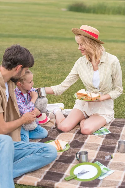 Lykkelig Familie Som Spiser Smørbrød Mens Sitter Pyntebånd Piknik – stockfoto