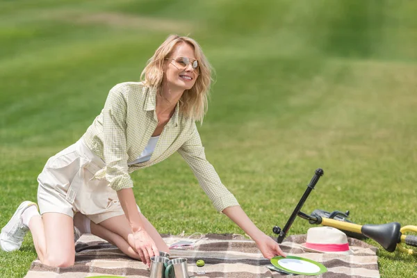 Glückliche Junge Frau Legt Beim Picknick Besteck Auf Karo — kostenloses Stockfoto