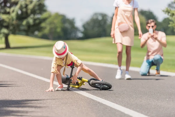 Eltern Fotografieren Kleine Tochter Die Park Vom Fahrrad Fällt — Stockfoto
