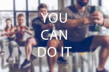 bulanık grup içinde spor salonunda egzersiz dumbbells ile atletik genç insanlar yazıt yapabilirsin