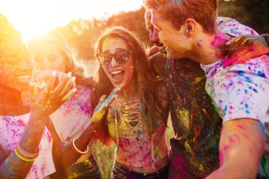 happy young multiethnic friends having fun together at holi festival  clipart