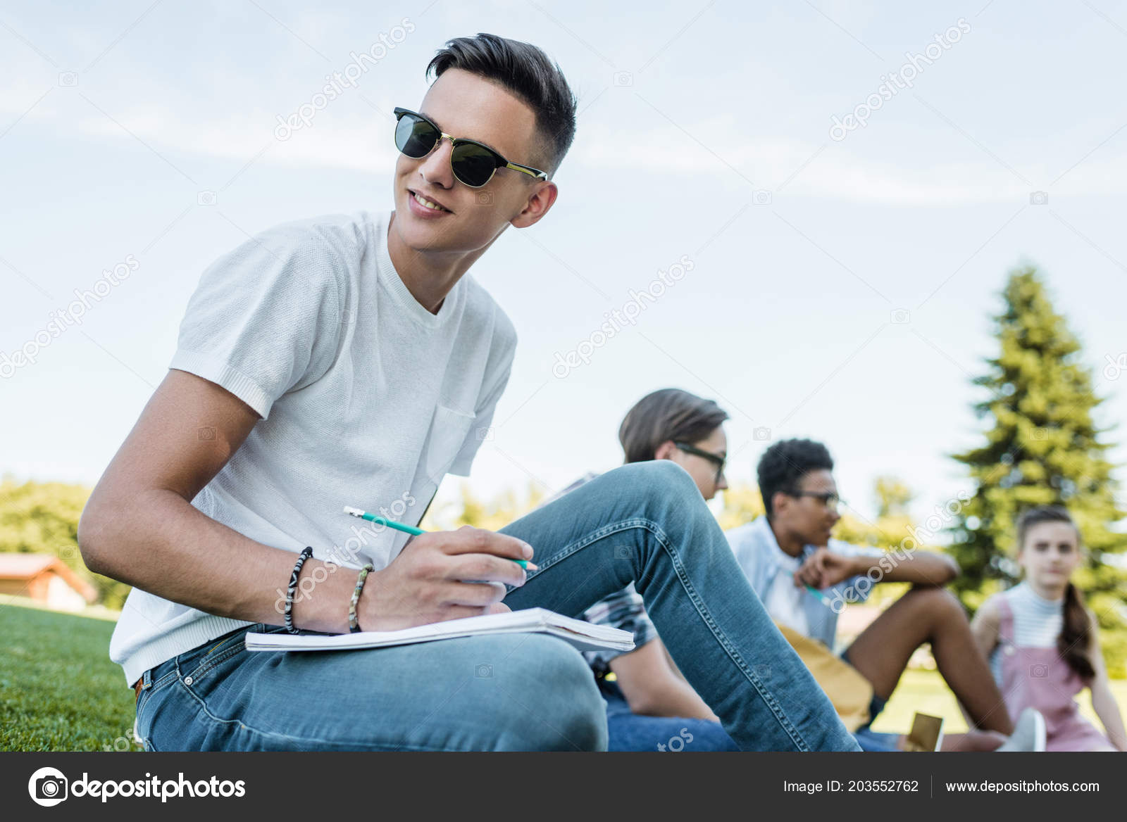 Smiling Teenage Boy Sunglasses Taking Notes Looking Away While