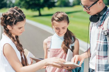 Genç öğrenciler kitap birlikte parkta okuma gülümseyerek