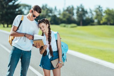 mutlu gençler süre ayakta ve birlikte parkta gülümseyen kitaplar holding 