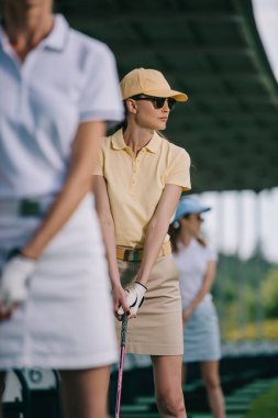 seçici odak kadın kap ve golf sahasında golf oynayan güneş gözlüğü