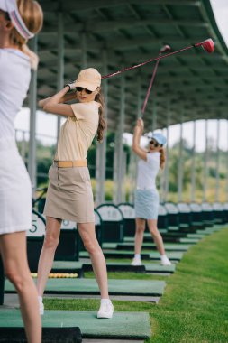 kadın golf oyuncu golf golf sahasında oynarken golf kulüpleri ile seçici odak